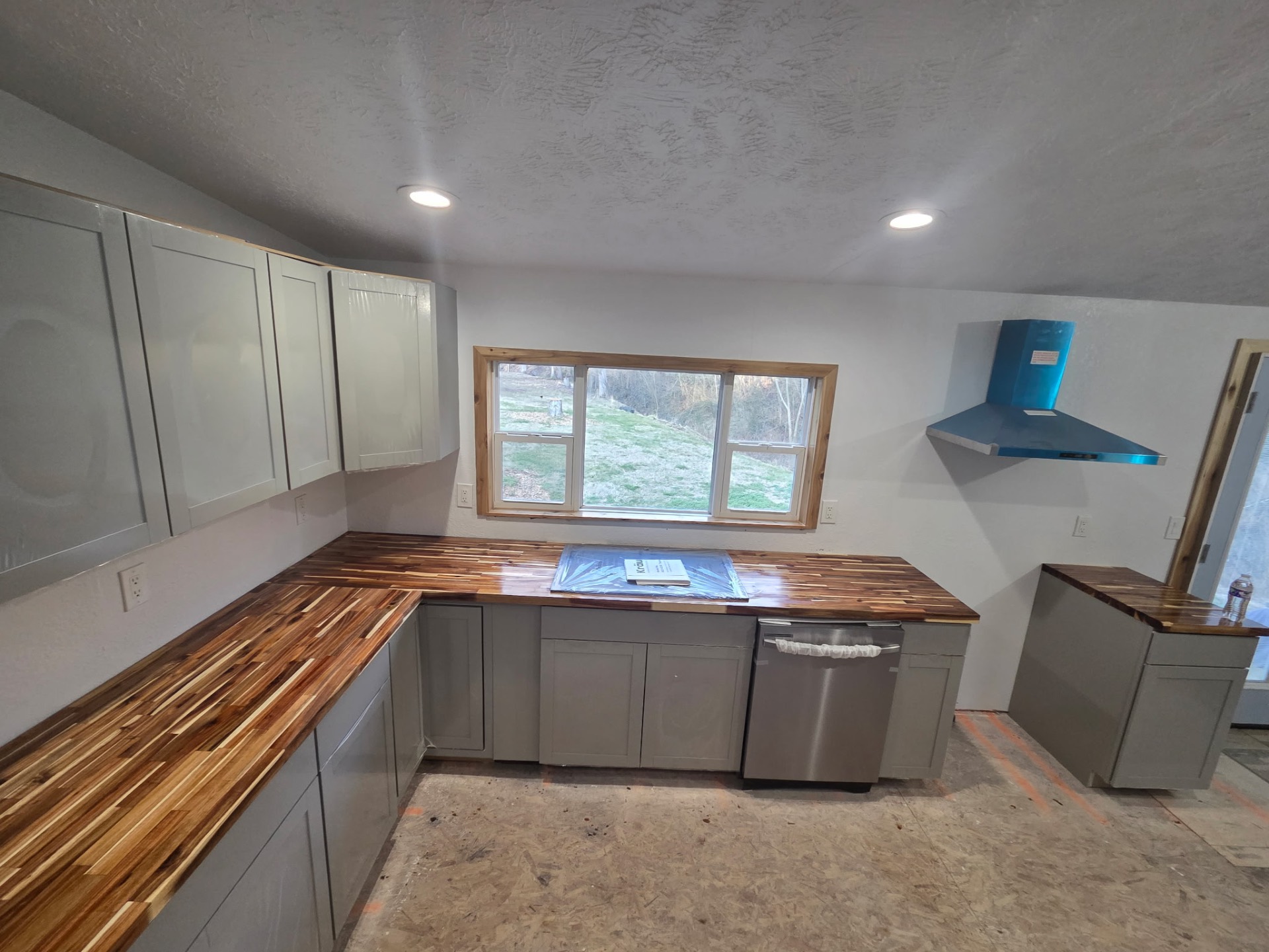 L-shaped gray kitchen with newly installed butcher block counters