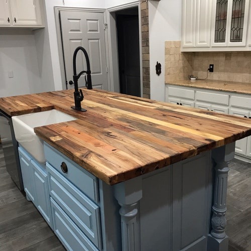 Rustic mixed-wood butcher block island with farmhouse sink