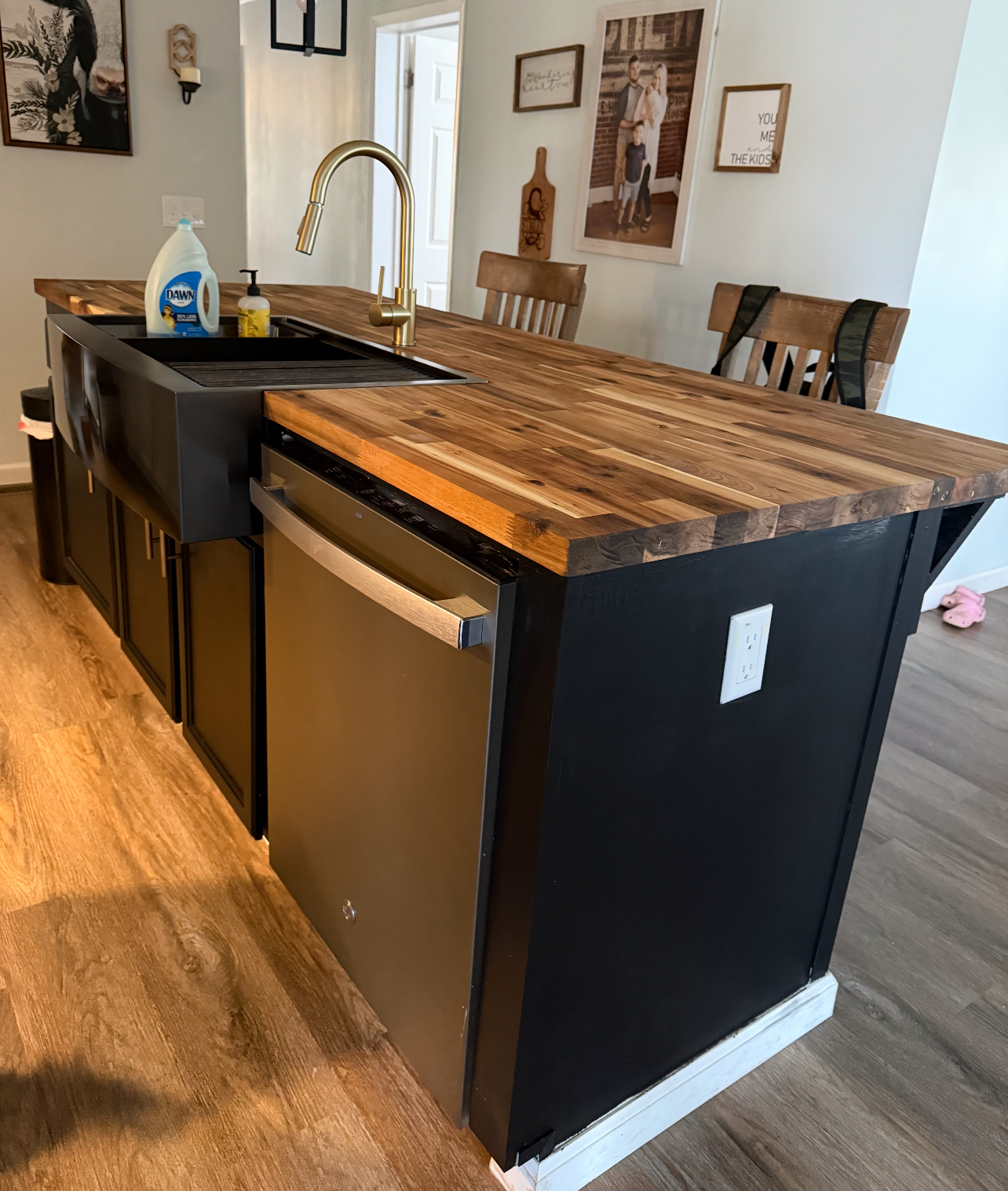 Butcher block island with black farmhouse sink and gold faucet