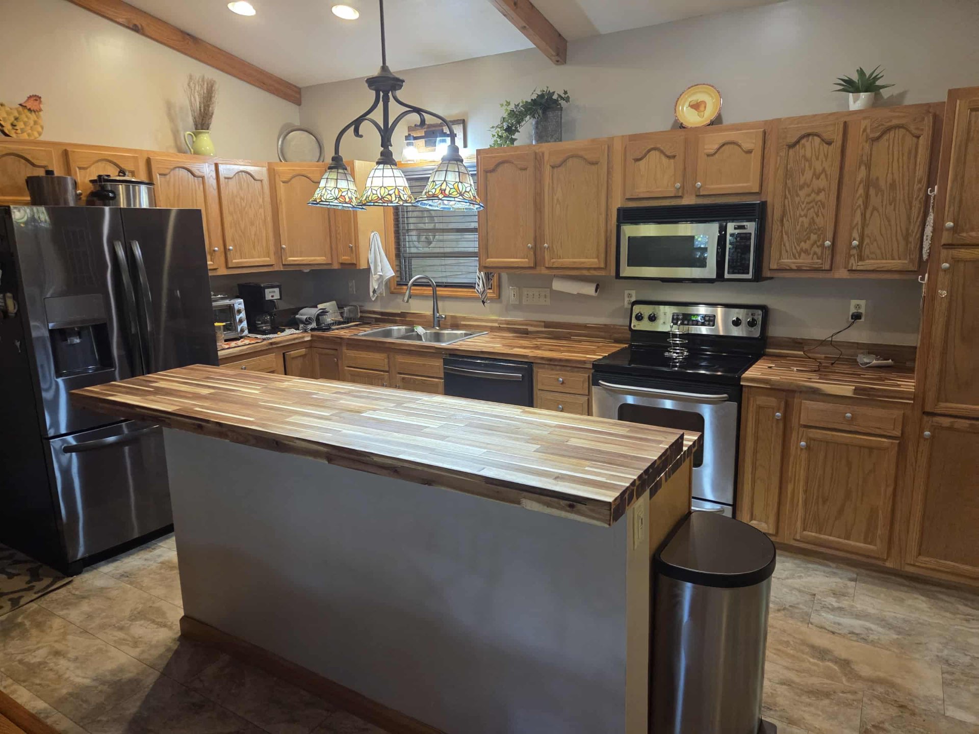 Acacia butcher block breakfast bar in a warm oak kitchen