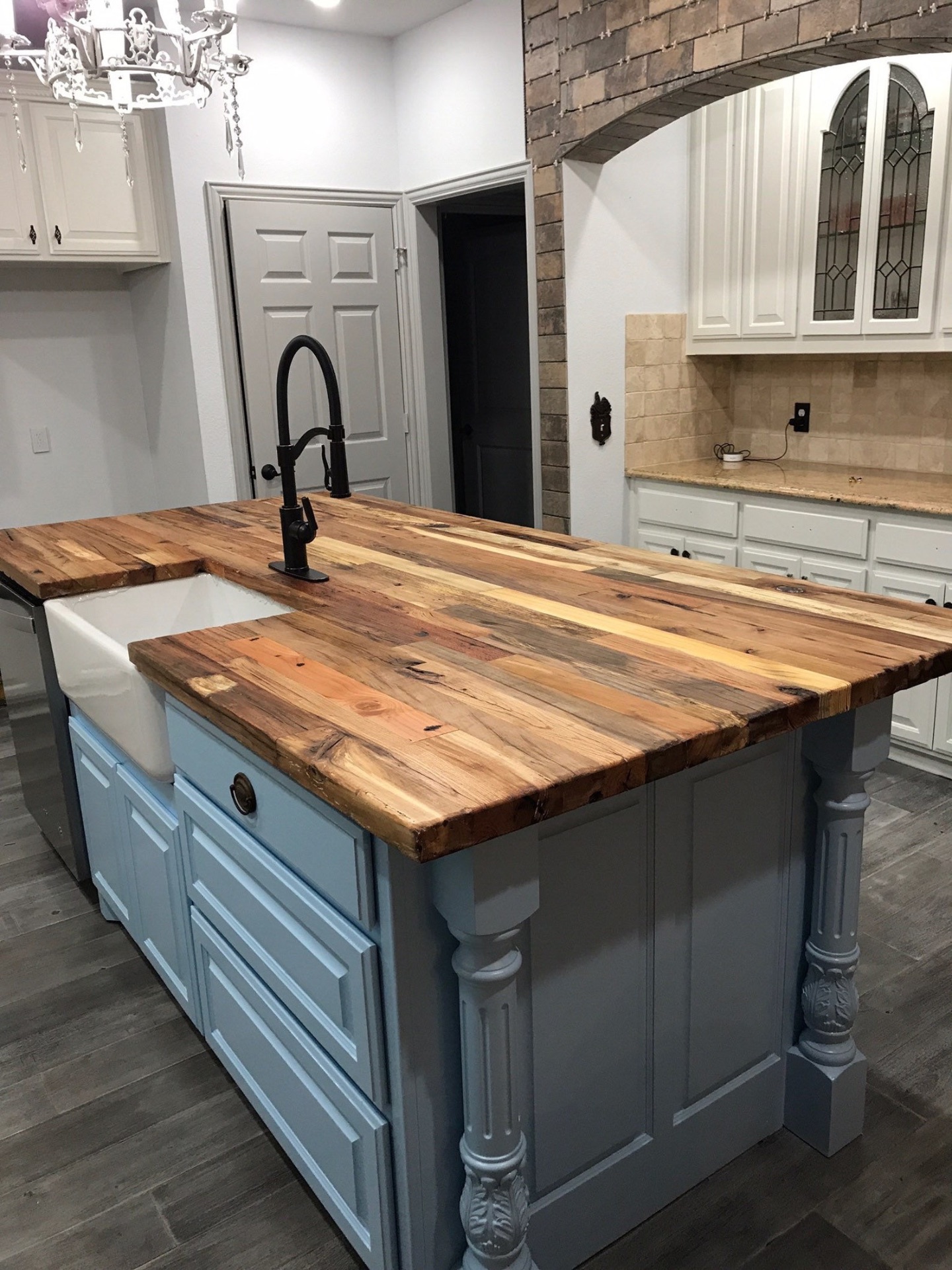 Reclaimed wood island countertop with apron sink on a gray base