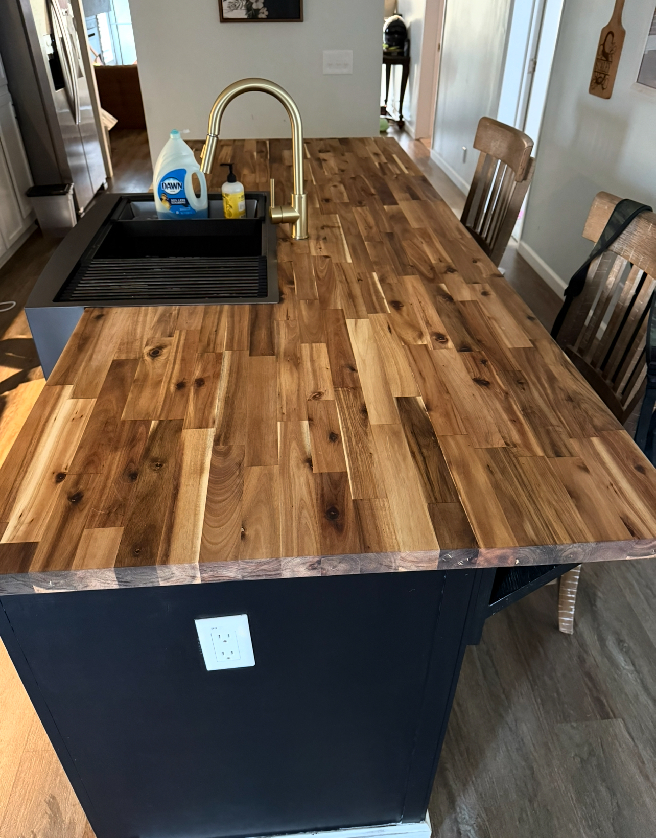Navy blue island topped with acacia butcher block and gold faucet