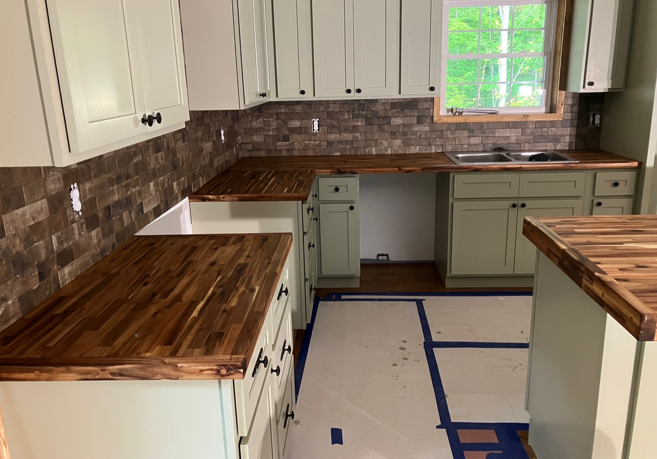 U-shaped kitchen with walnut butcher block counters and sage cabinets